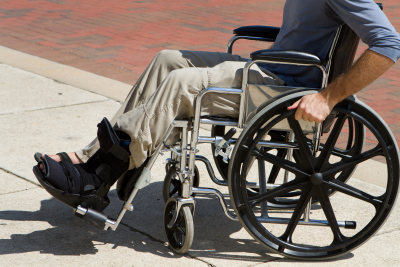 Injured man pushes himself along in his wheelchair