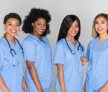 four nurses smiling